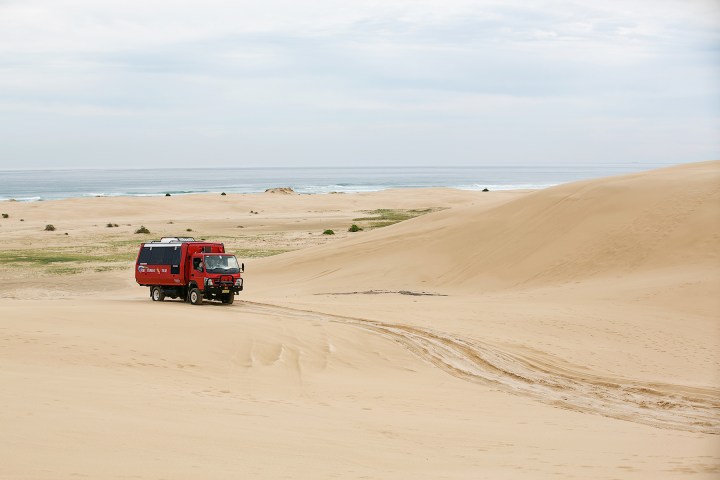 a truck traveling down a sandy beach