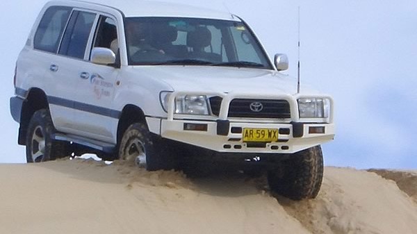 Cruiser-crop a white truck driving down a dirt road