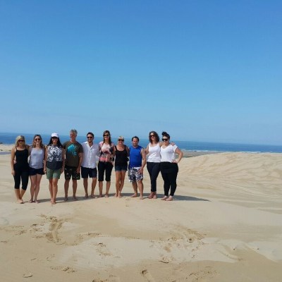 a group of people standing on top of a sandy beach