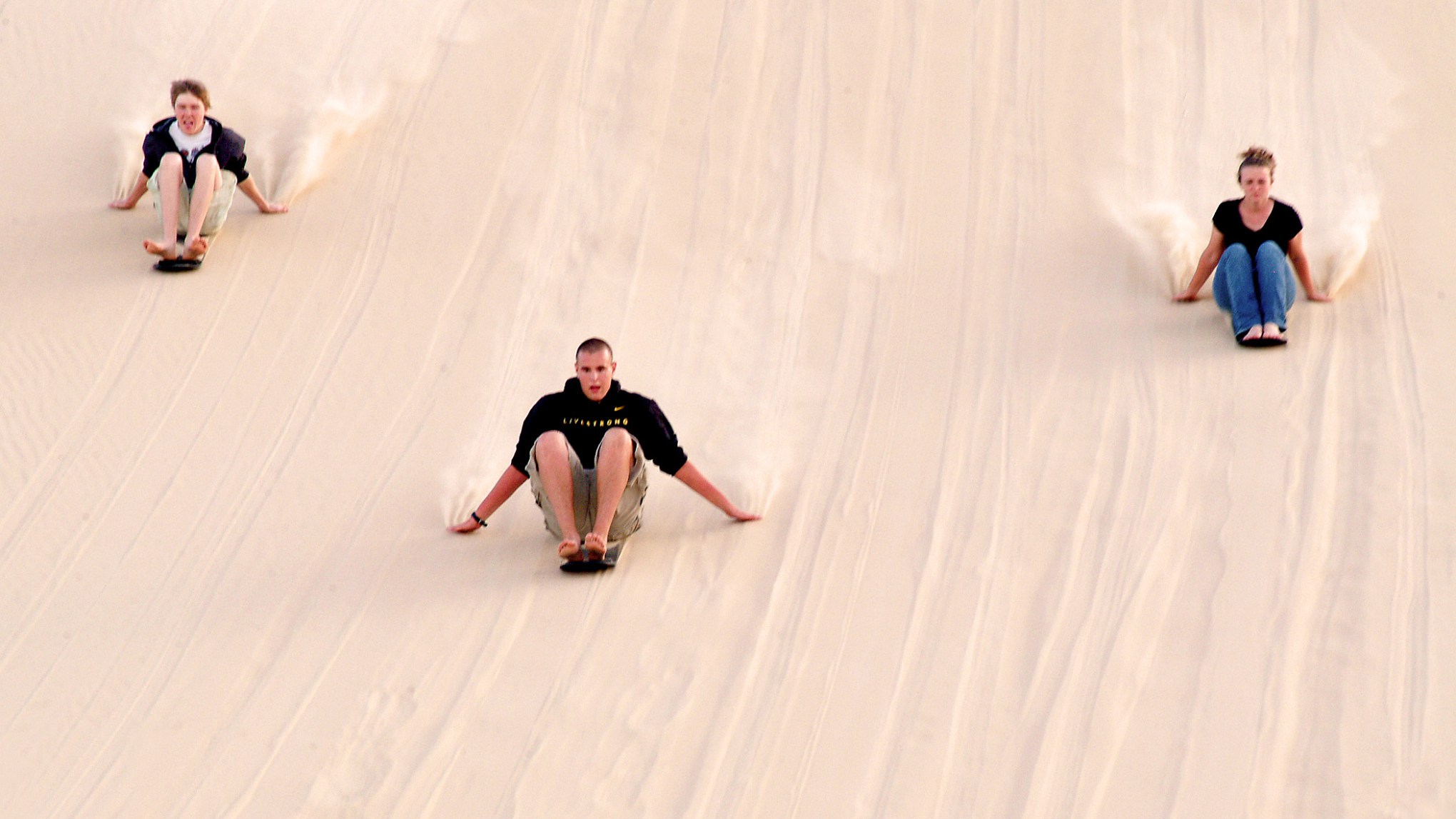 a group of people riding skis down a snow covered slope