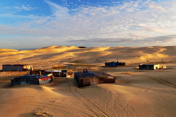 a truck that is driving down the beach