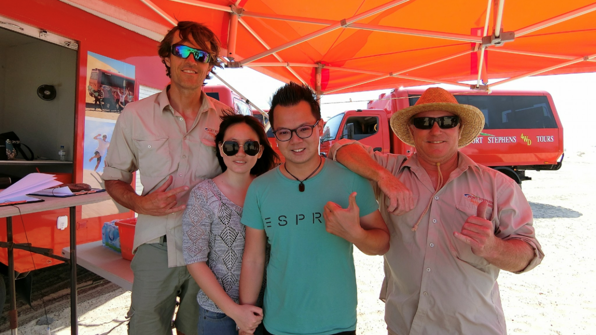 a person standing in front of Alan Yau et al. posing for the camera